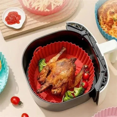El molde dentro de la canasta de la freidora con pollo y verduras