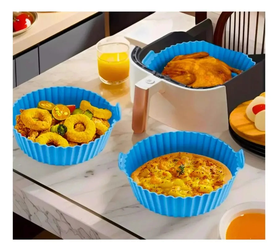 Moldes de silicona con comida junto a una freidora de aire
